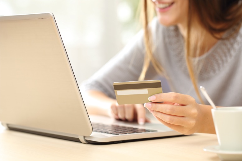 young woman using laptop and credit card