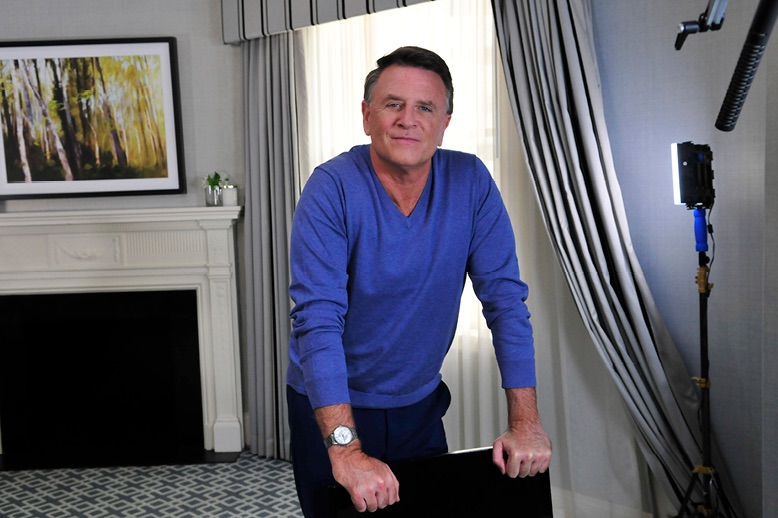 david chilton wearing blue sweater leaning on chair