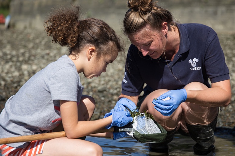 woman and child examining wildlife in water