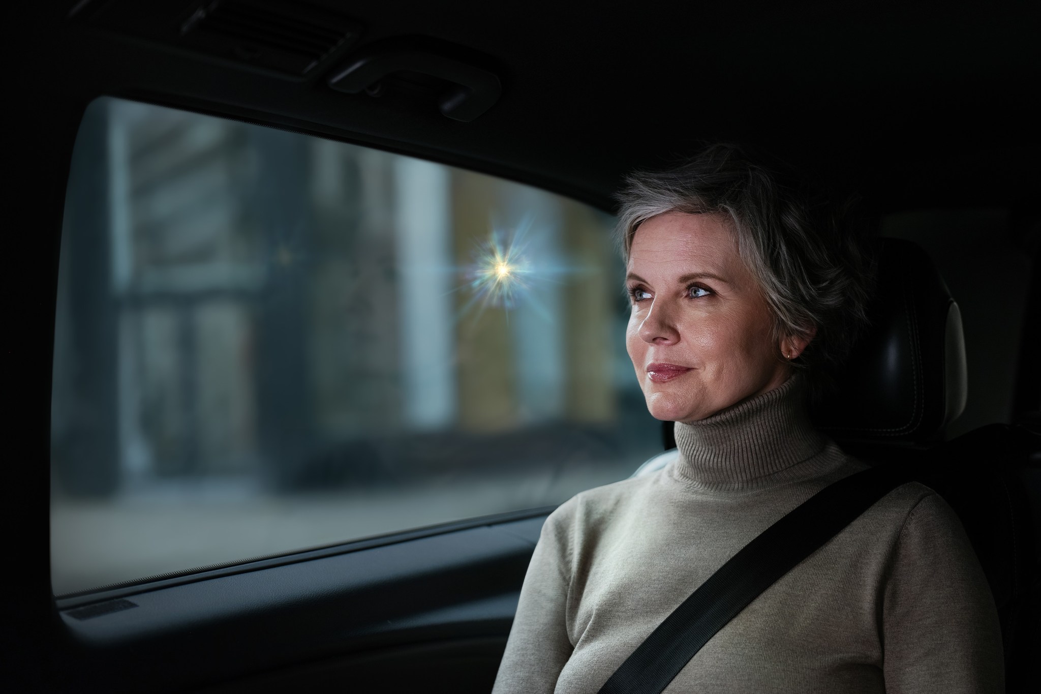 Woman sitting in car with a small spark near her head