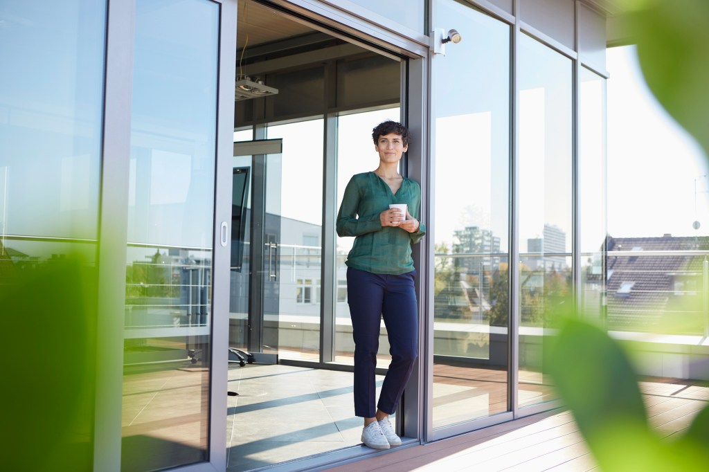 woman on balcony holding a cup of coffee