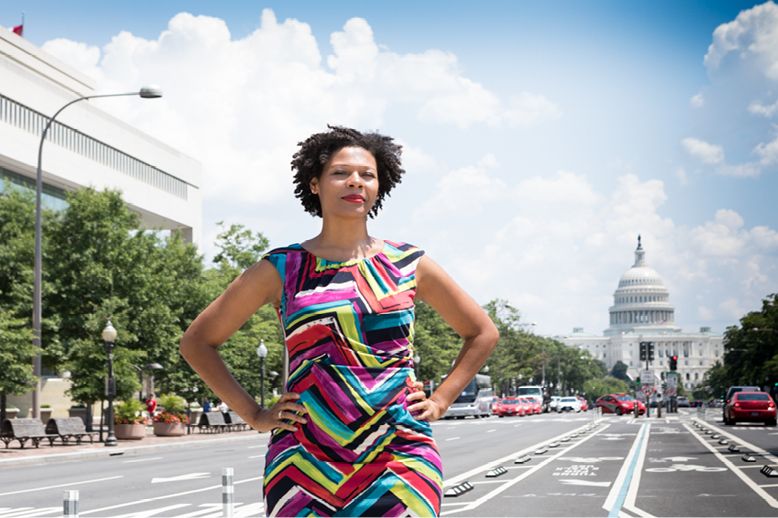 woman standing with hands on hips in street with White House in background