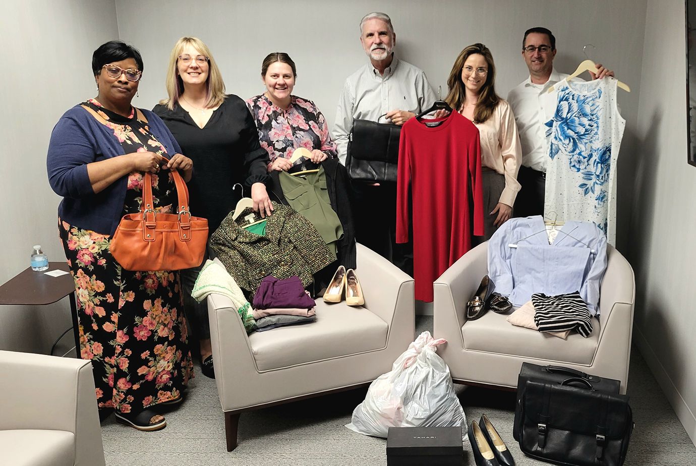 Photo of RBC Wealth Management employees holding clothing donations.