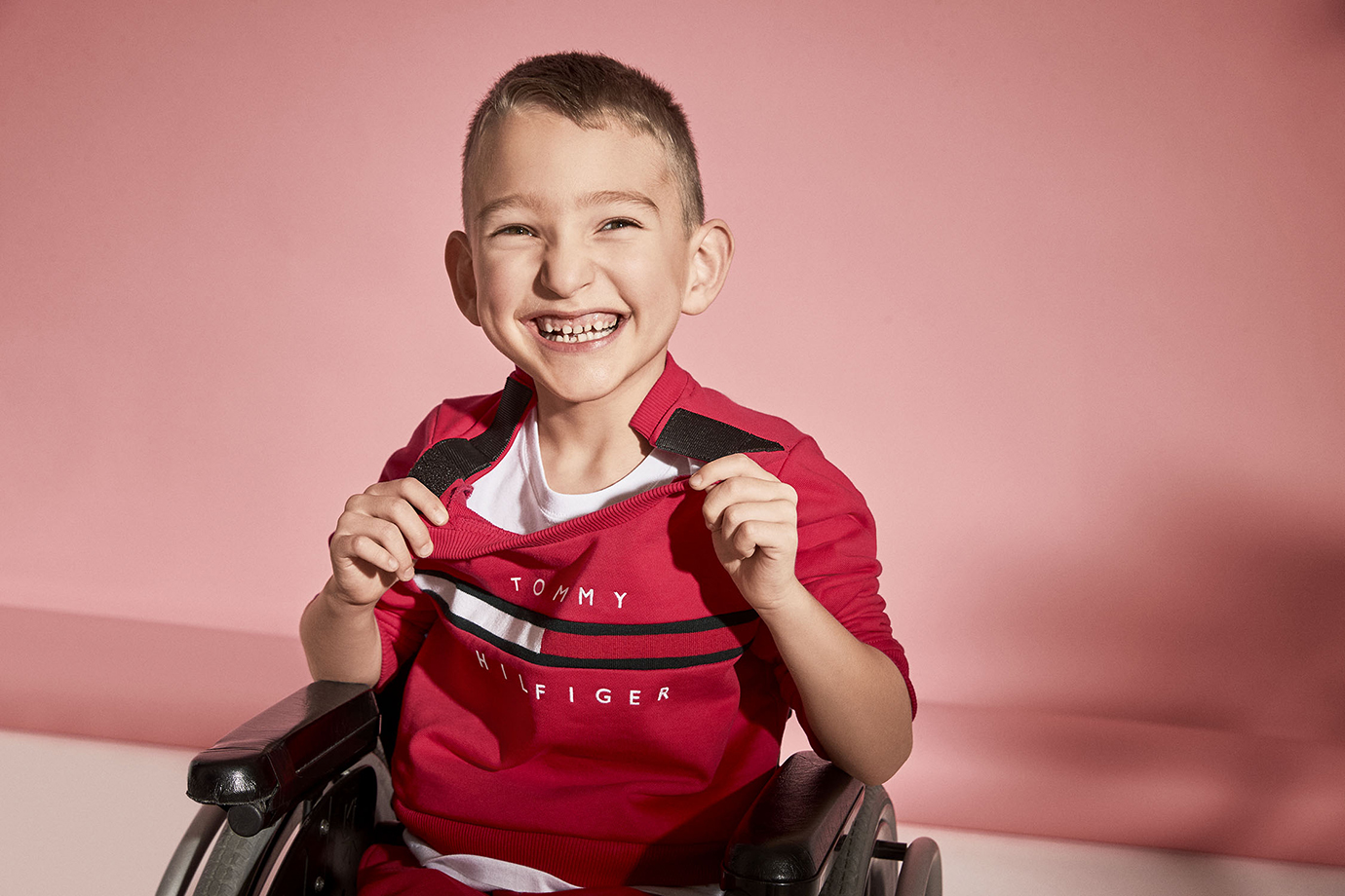 Photo of child model in wheelchair wearing Tommy Adaptive clothing