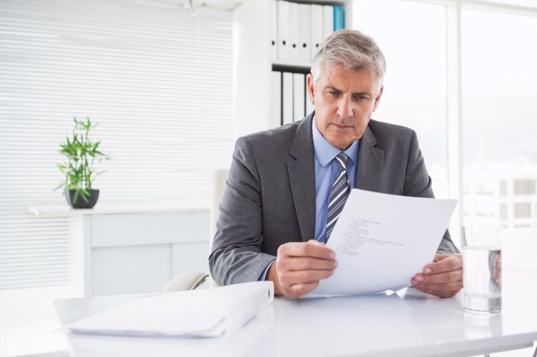 business man holding paper at desk