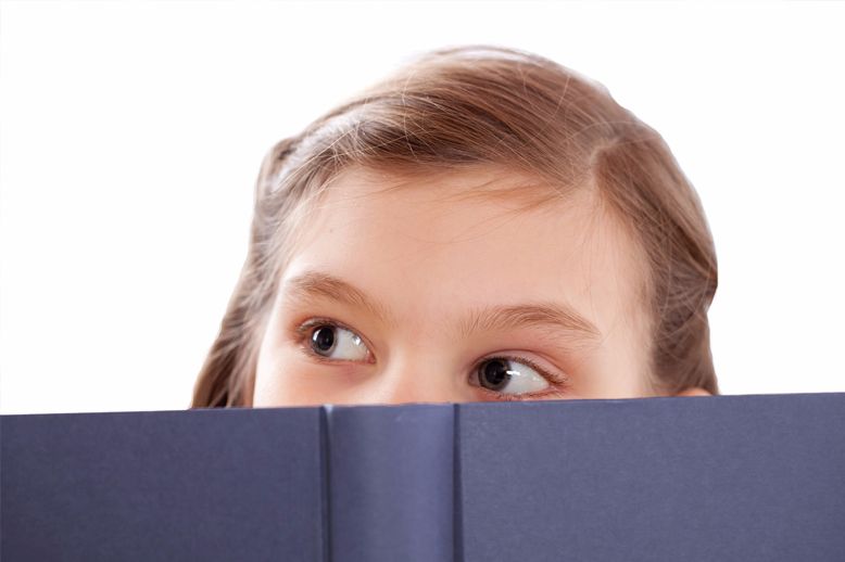 girl peeping over book