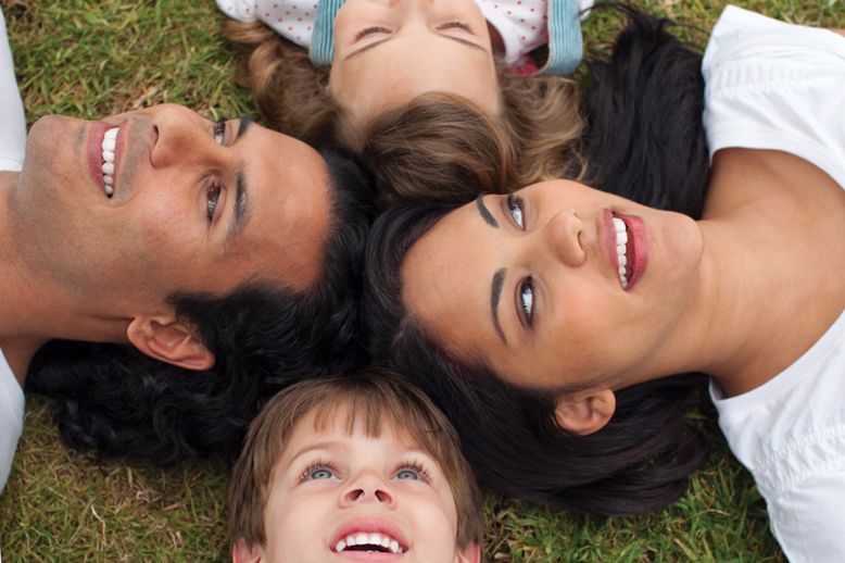 mom dad daughter son lying on grass